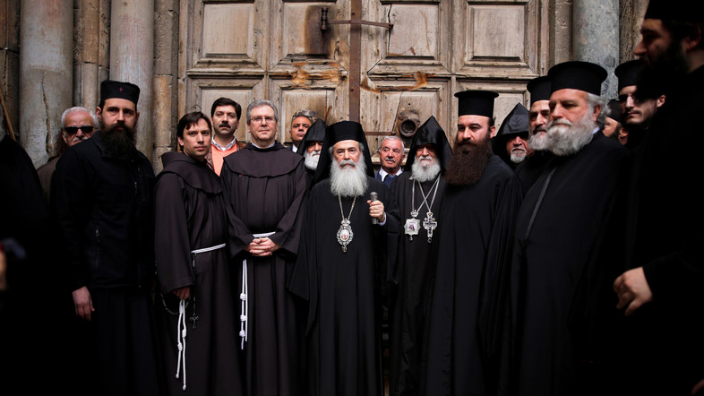 The Custodian of the Holy Land Father Francesco Patton (3rd L) and Greek Orthodox Patriarch of Jerusalem, Theophilos III (C) stand with other church leaders during a news conference in front of the closed doors of the Church of the Holy Sepulchre in Jerusalem's Old City, February 25, 2018. REUTERS/Amir Cohen - RC1B1D036C90