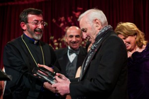Archbishop Khajag Barsamian presents an award to Charles Aznavour as members of the Fund for Armenian Relief Board of Directors look on. (photo credit: Edmond Terakopian).